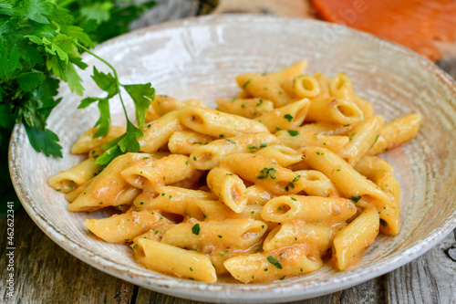  Italian home made   pennette pasta with smoked salmon , creamy sauce and fresh dill on wooden background