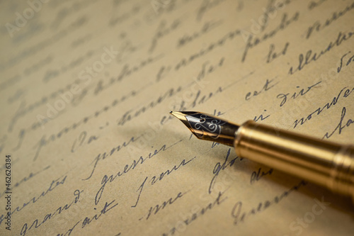 Vintage writing utensils on a wooden table, old watch, papers, letters, envelopes and scissors