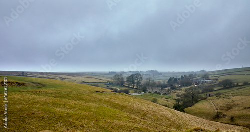 Hazy and gloomy image of upland hamlet of Moorhouses with grass covered spoil heaps