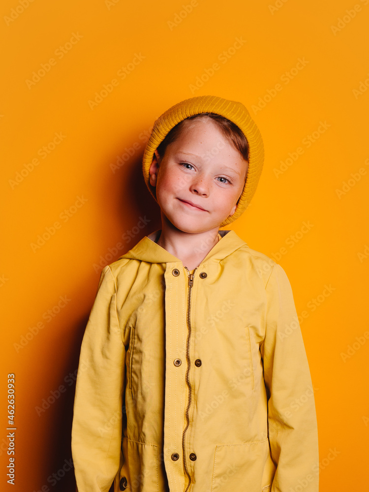 Laughing boy looking at camera against yellow background