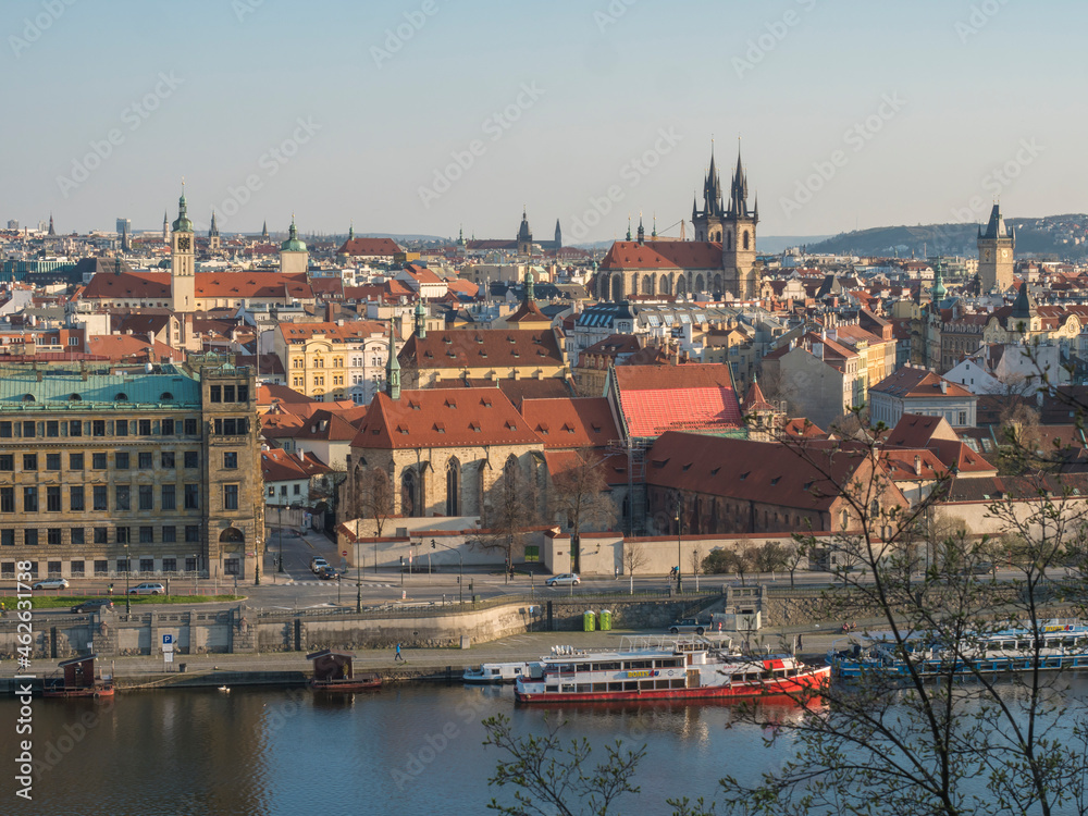 Scenic aerial view of Prague Old Town architecture roof top over Vltava river with houseboat seen from Letna hill park, spring sunny day, blue sky, Czech Republic