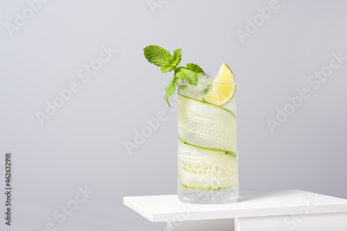 Refreshing cocktail with lime and cucumber served on white table photo