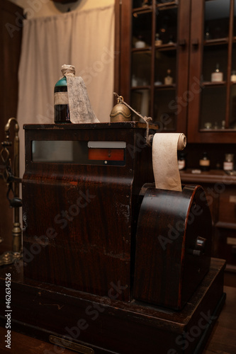 Vintage cash register in old pharmacy. Wooden antique furniture for medical drug storage