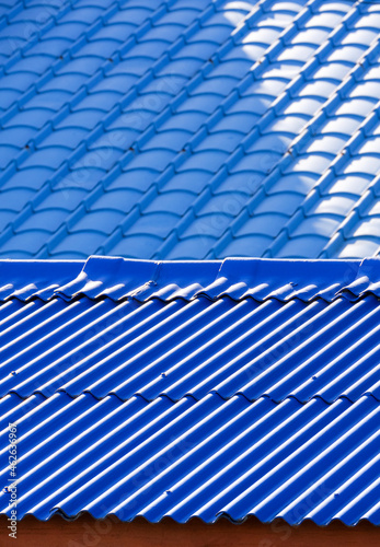 Abstract background pattern of blue tile roofs with sunlight and shadow on surface in perspective vertical view, focus on foreground