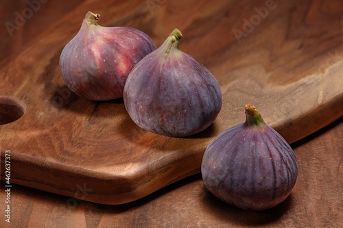 A fresh whole figs with on a wooden kitchen board. Food Photo. Ripe delicious figs on wooden background. Selective focus..