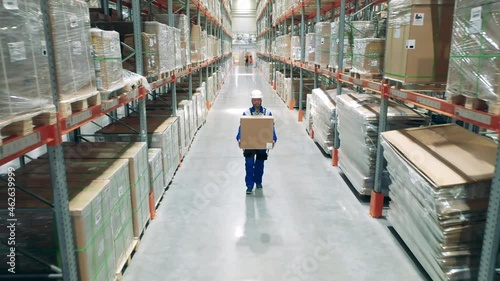 Wallpaper Mural Storehouse worker is carrying a heavy box through the premises Torontodigital.ca