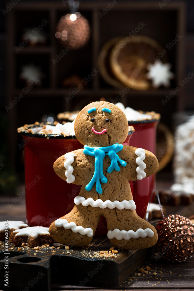 Fototapeta premium winter treats, gingerbread man cookies and hot chocolate, vertical