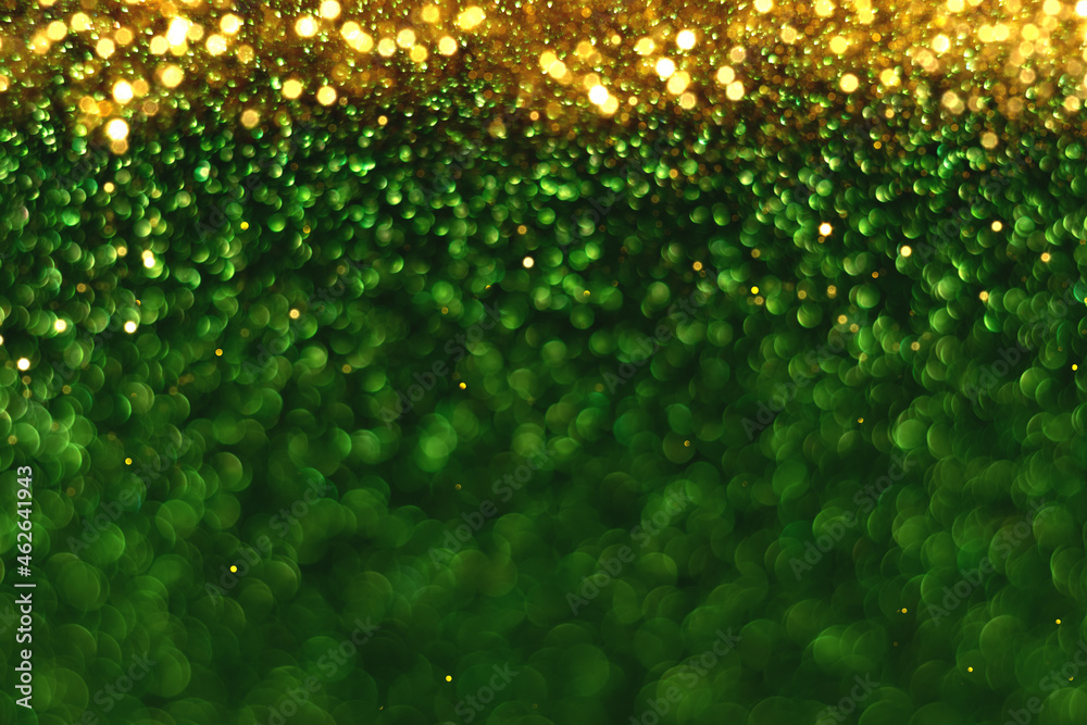 Green and gold sparkling glitter bokeh background, christmas abstract defocused texture. Holiday lights