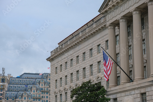 Oppulent impressive building architecture facades with columns, domes and statues of government houses in Washington D.C., DC with American flag Stars and Stripes banner photo