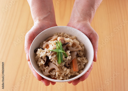 Takikomi Gohan Vegetable Fried Rice with Meat, Fish, Mushrooms. Man Holding a Bowl of  Traditional Japanese Rice Dish. photo