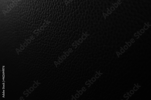 Abstract dark background of black leather texture close-up. Selective focus