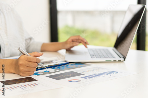 a businessman with a pen working in the office using a calculator to calculate financial accounting figures or financial experts analyze graphs, charts, finance concepts. banking business and stock ma