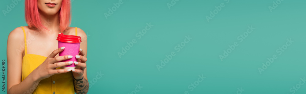 cropped view of young woman with pink dyed hair holding paper cup isolated on blue, banner cropped view of young woman with pink dyed hair holding paper cup isolated on blue, banner