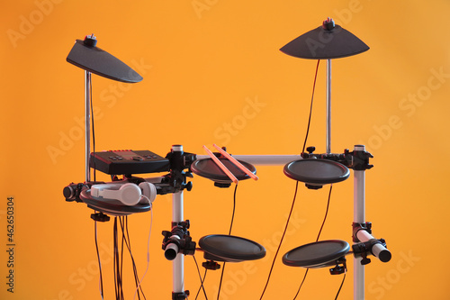 Modern electronic drum kit on orange background. Musical instrument