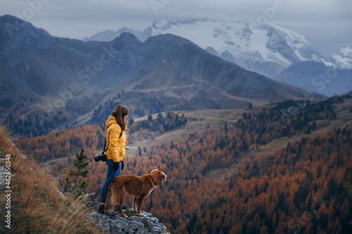 young woman with a dog at the top, peak. travel Nova Scotia Duck Tolling Retriever 