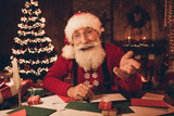Photo of aged santa claus happy positive smile speak talk wish merry christmas illumination north pole indoors