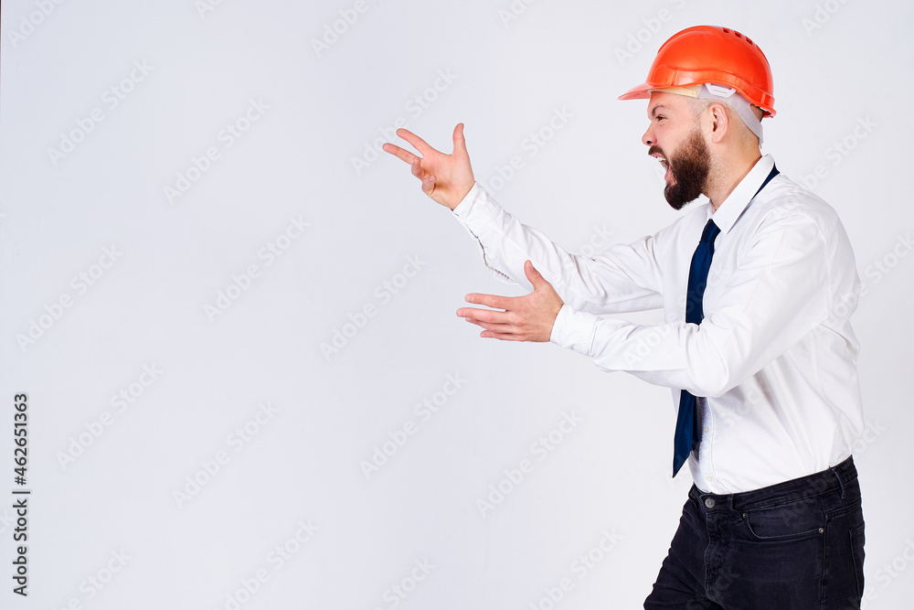 Angry man in a protective helmet of a builder on an isolated white background. Angry man in a protective helmet of a builder on an isolated white background.