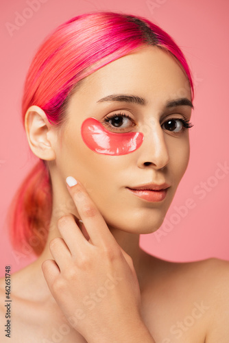 pretty young woman with colorful hair and moisturizing eye patch isolated on pink