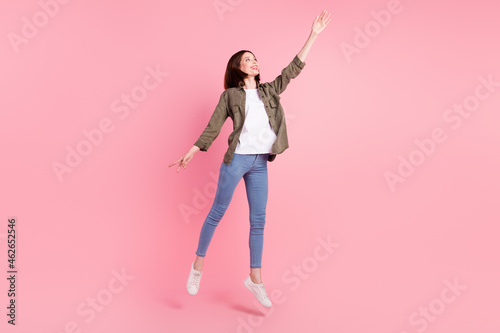 Full body photo of nice short hairdo lady dance look up wear khaki shirt jeans sneakers isolated on pink color background