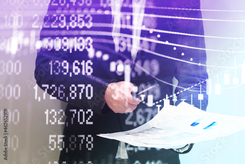 Double exposure of young business man and digital number of stock market background to represent successful in investment marketing. Find out the best solution in business and financial as concept. 