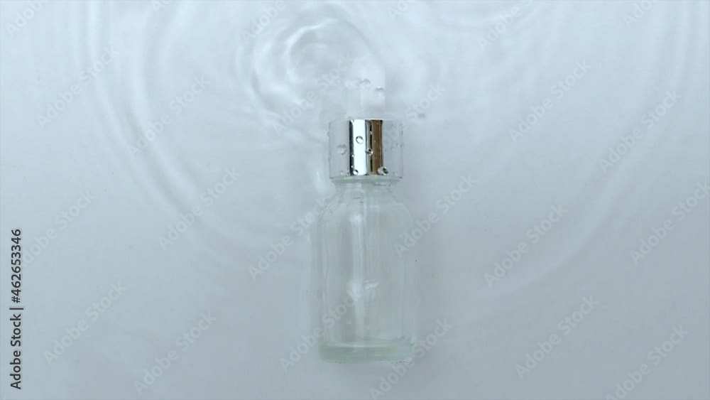 Cosmetics in a bottle on a water background. Hyaluronic acid. Cosmetics in a bottle on a water background. Hyaluronic acid.
