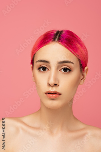 pretty young woman with colorful hair and makeup looking at camera isolated on pink