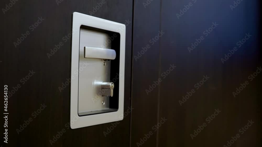 gray metal handle with lock on wooden door