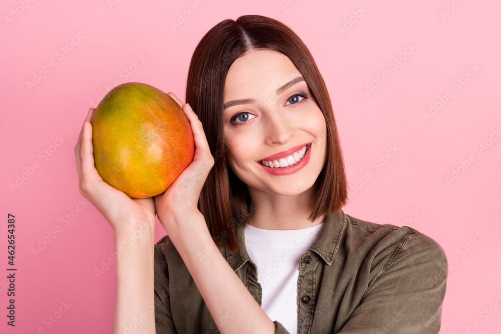 Photo of cool brunette hairdo young lady hold mango wear green shirt isolated on pink color background Photo of cool brunette hairdo young lady hold mango wear green shirt isolated on pink color background
