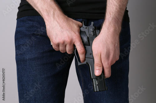 Man reloading gun on grey background, closeup