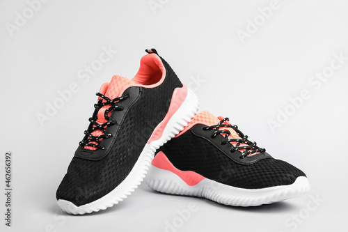 Pair of comfortable sports shoes on light grey background