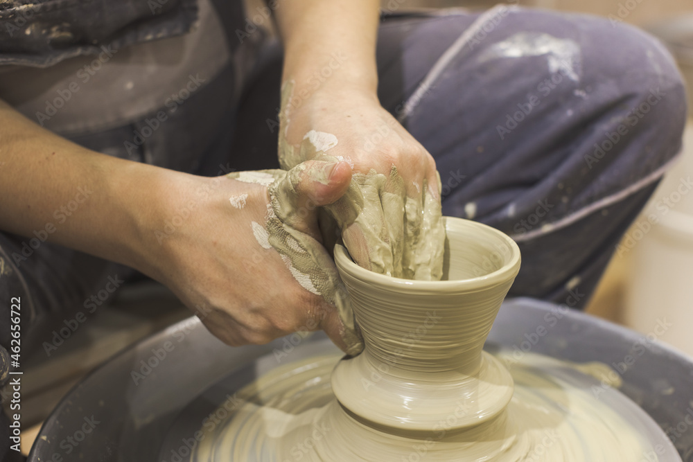 Ceramic Artist hands mold clay on pottery wheel. Arts creative workshop.