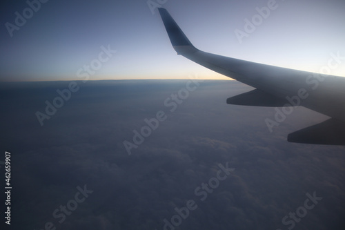 Flying and traveling, view from airplane window on the wing on sunset time. Flight in sky. 