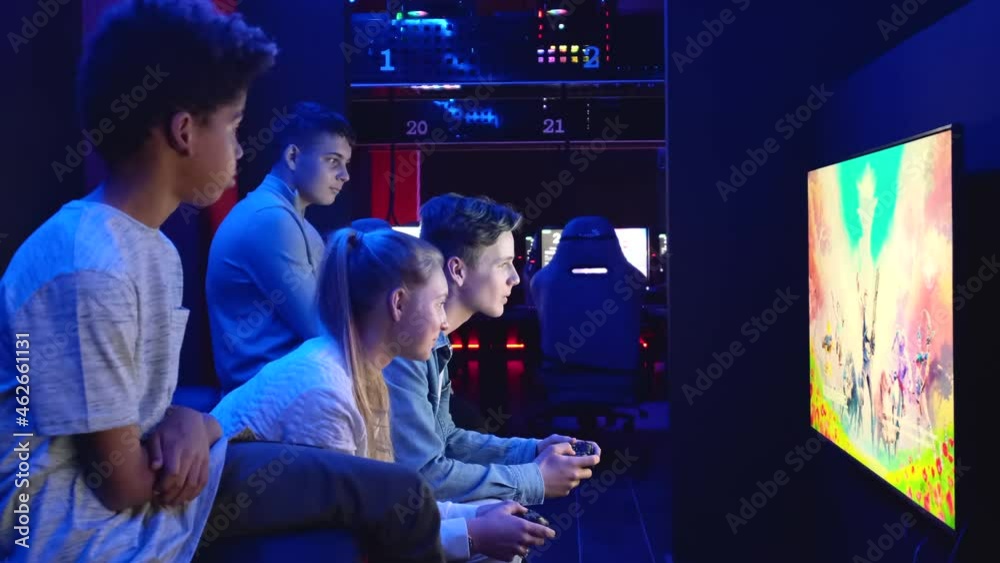 Group of young multiethnic diverse teen sit in cybercafe use pc play on-line video game in dark room. E-sport online competitions event, modern tech, gen z addict with virtual games concept Group of young multiethnic diverse teen sit in cybercafe use pc play on-line video game in dark room. E-sport online competitions event, modern tech, gen z addict with virtual games concept