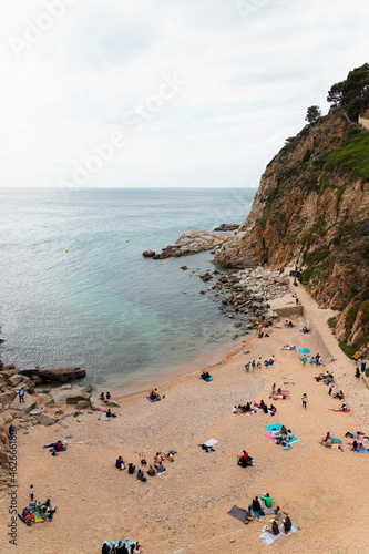 GIRONA, SPAIN - April 4, 2021: View of a beach full of people enjoying spring time in Tossa de Mar