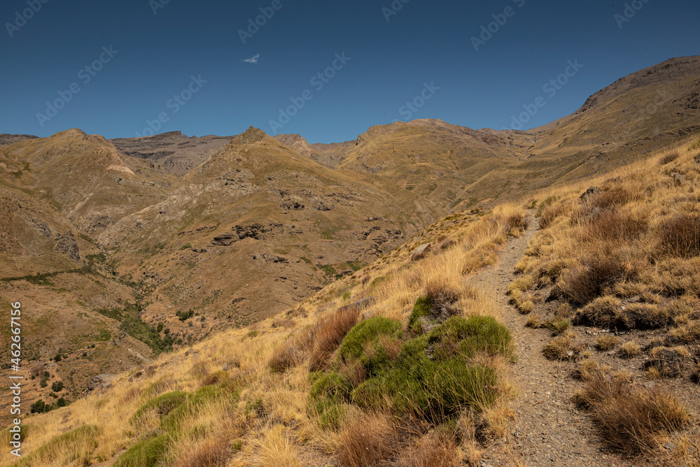 Scenic landscape with a hiking trail in the beautiful Poqueira Valley underneath Mount Mulhacén, leading to Capileira village, Las Alpujarras, Sierra Nevada National Park, Andalusia, Spain