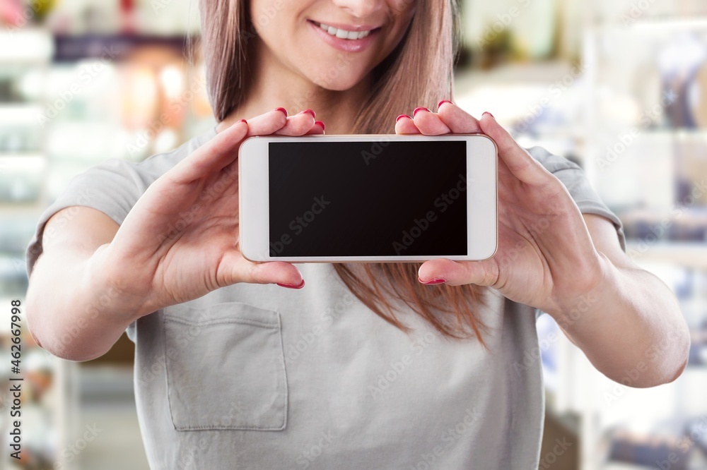 Excited Young woman Pointing On Smartphone With Blank Screen In His Hands,