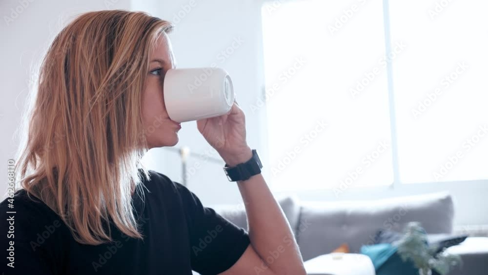 Blond Modern Woman working on a Computer while drinking coffee or tea Blond Modern Woman working on a Computer while drinking coffee or tea