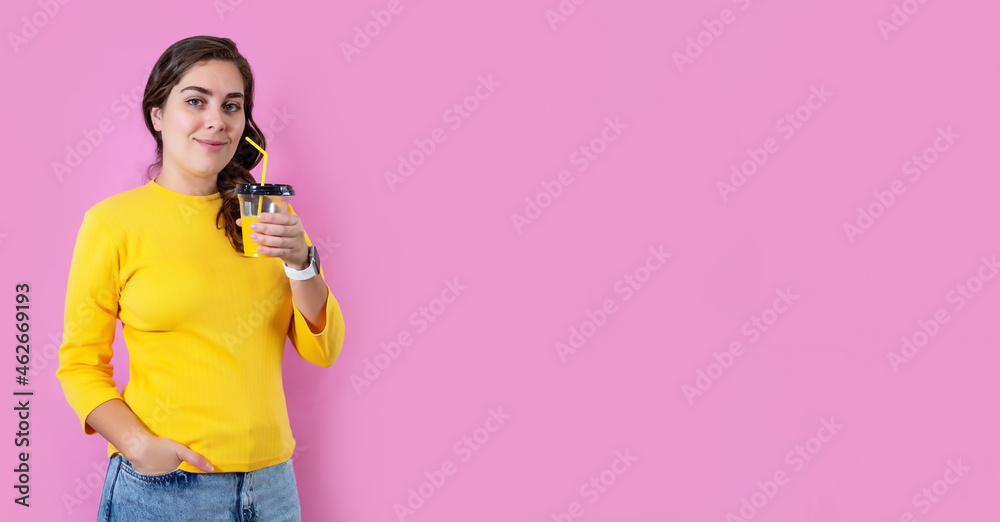 Smile woman drinking orange juice in isolated on pastel pink background.