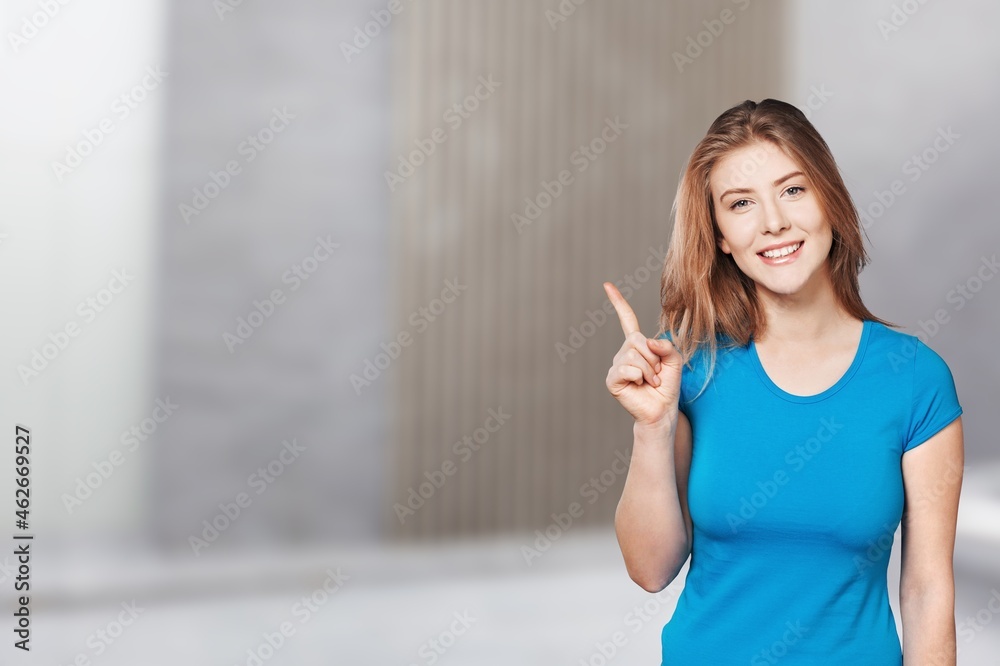 Joyful lady pointing at blank space, in excitement over background. Joyful lady pointing at blank space, in excitement over background.