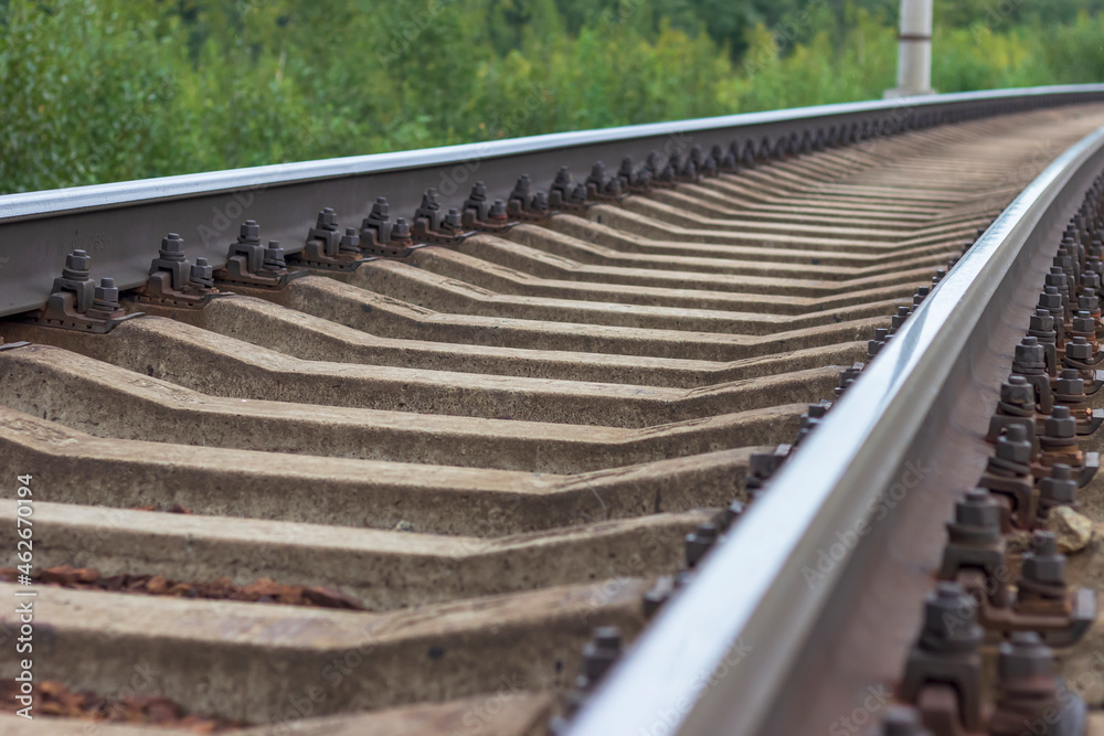 Railway rails and sleepers close-up. A railway that goes around a bend in the distance. Railway rails and sleepers close-up. A railway that goes around a bend in the distance.