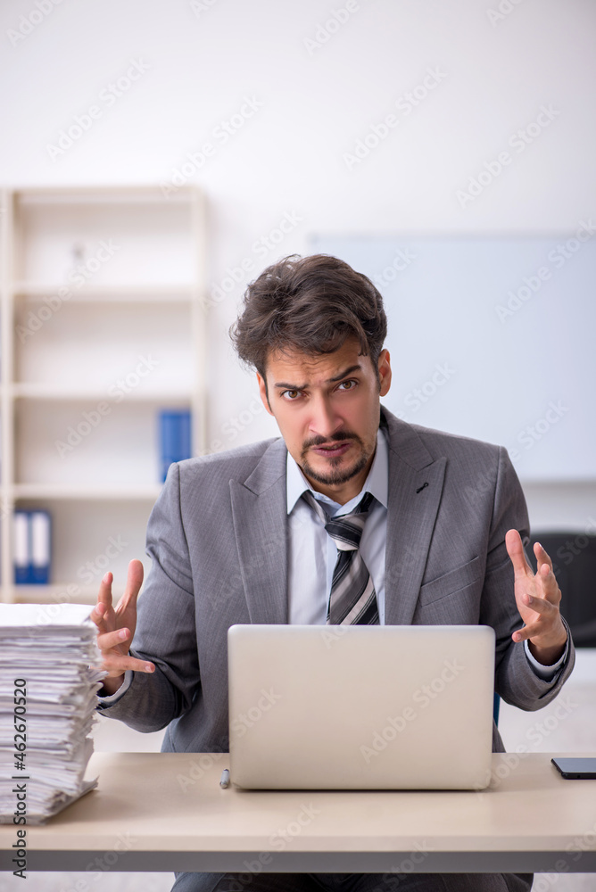 Young businessman employee and too much work in the office Young businessman employee and too much work in the office