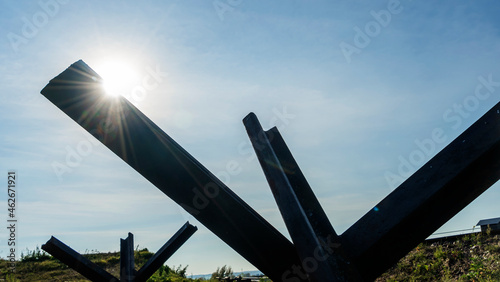 Iron anti-tank barrier from World War II. Anti Hedgehog Barbed Wire on blue sky background.