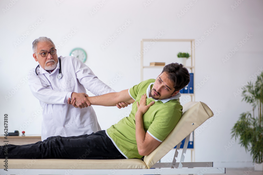 Obraz premium Young male patient visiting old male doctor