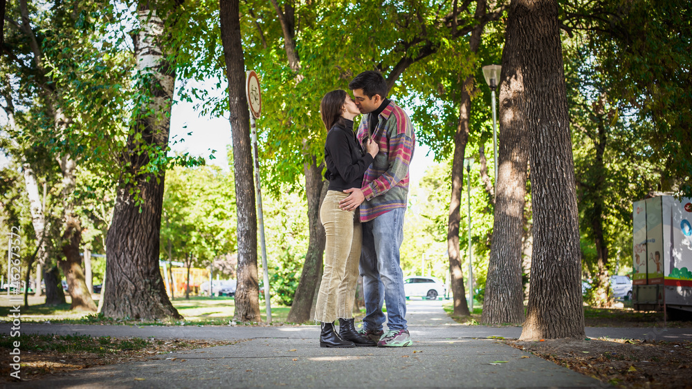 Fototapeta premium Couple in love hugging and kissing in park. French deep kiss.