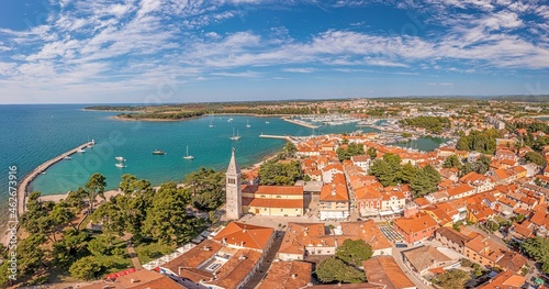 Drone panorama over the roofs of the Croatian coastal town of Novigrad with harbor and church during daytime