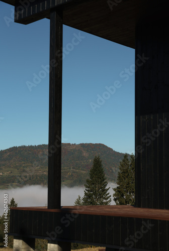 View of foggy valley from terrace of wooden black house