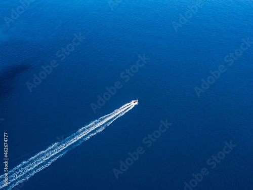 Top view of a motorboat sailing in clear water of the blue sea