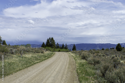 Landscape of unpaved road in the countryside under a cloudy sky photo