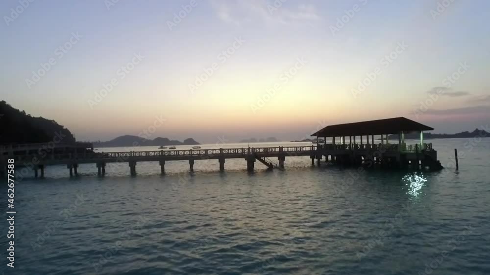 Moving backwards view of the jetty and boat in background during twilight. relaxing beach and relaxing seascape. Moving backwards view of the jetty and boat in background during twilight. relaxing beach and relaxing seascape.