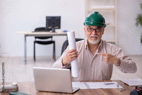 Old male architect working in the office